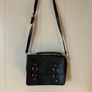 Black structured crossbody bag w/ gold hardware. Flap & snap closure.
